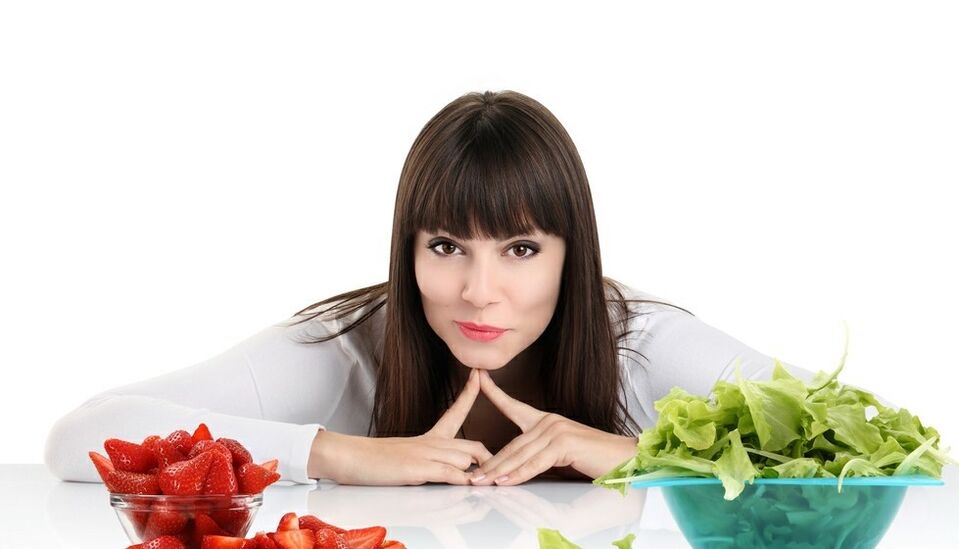 femeie la masă cu ierburi și căpșuni